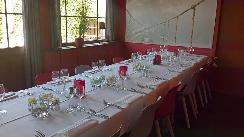 Lange gedekte feesttafel met bloemen in de rode eetzaal